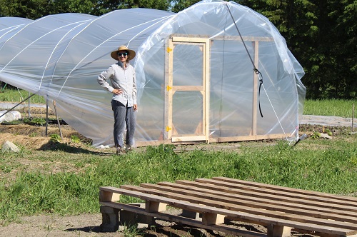 Gabrielle devant une serre en construction