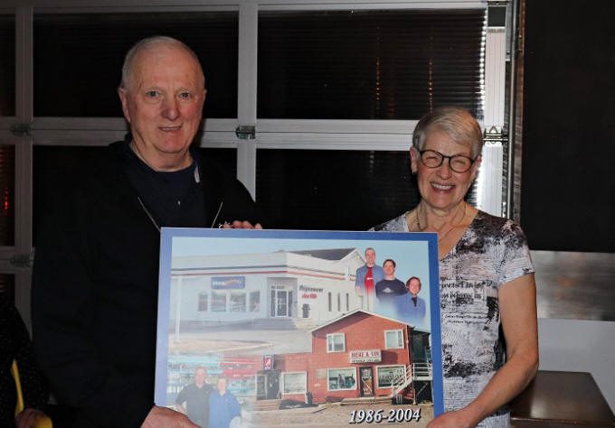 Laurette et Jacques Gibson avec une photo de leur dépanneur 1986-2004.