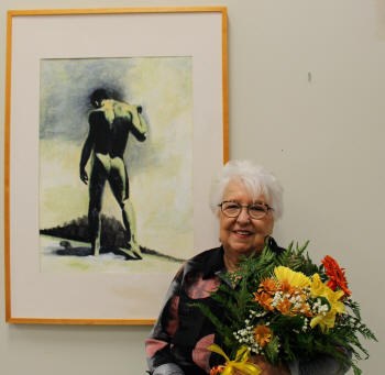 Mme Marie-Claire Dickey recevant des fleurs lors du vernissage de son exposition.