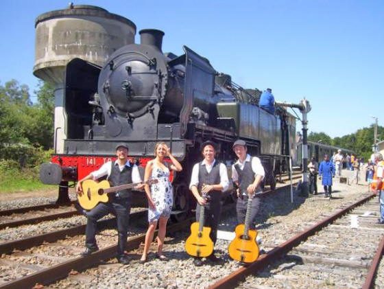 Le groupe Trio BBQ devant une locomotive