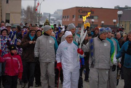 Le porteur de la flamme est entouré par une foule à Rouyn-Noranda.