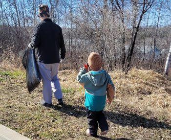 Un adulte et un enfant lors de la collecte des déchets