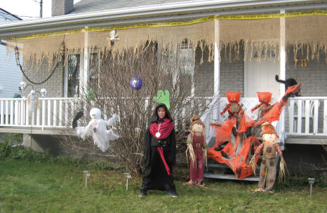 Enfant costumé devant une maison bien décorée