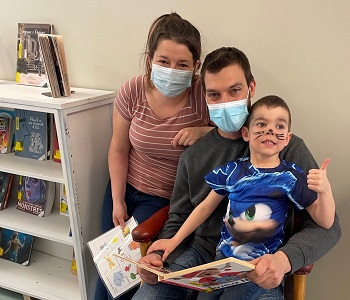 Deux adultes accompagnant un enfant à la bibliothèque