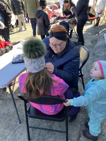 Un très jeune enfant observe avec attention une séance de maquillage