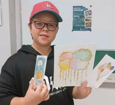 Un jeune homme nous montre fièrement ses aquarelles