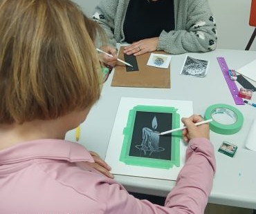 Dessin d'une chandelle en blanc sur carton noir