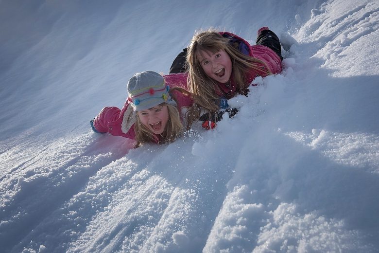 Fillettes glissant dans la neige