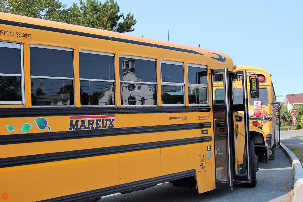 Autobus scolaire arrêté près d'une école à Évain.