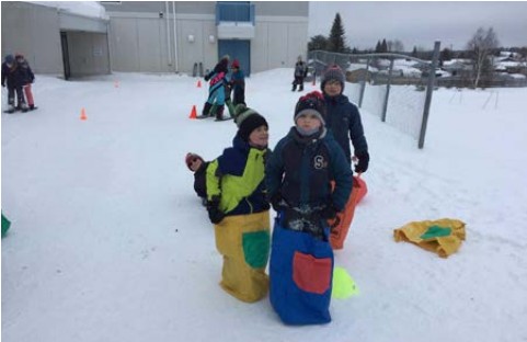 Enfants sautant lors d'une course en sacs...