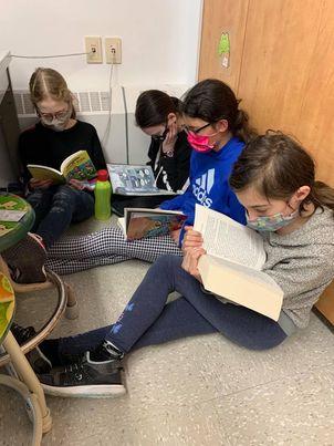 4 jeunes filles assises dans un coin pour lire