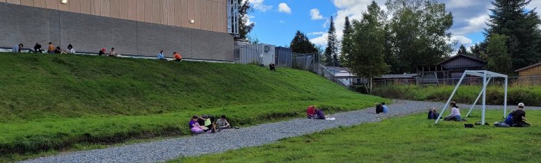 Des élèves travaillent dehors à l'arrière de l'école