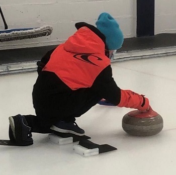 Élève lançant une pierre au curling