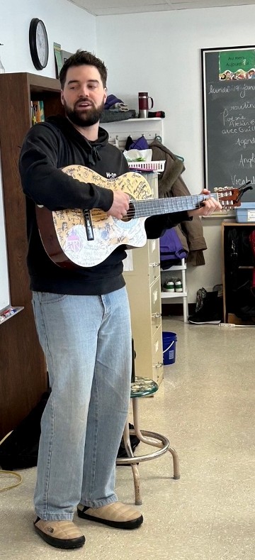 Guillaume Laroche à la guitare dans une classe de l'école
