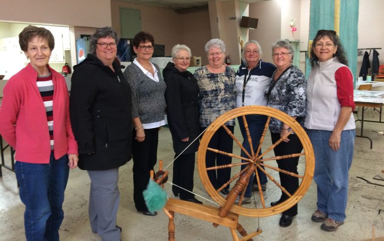 Fermières devant un grand rouet