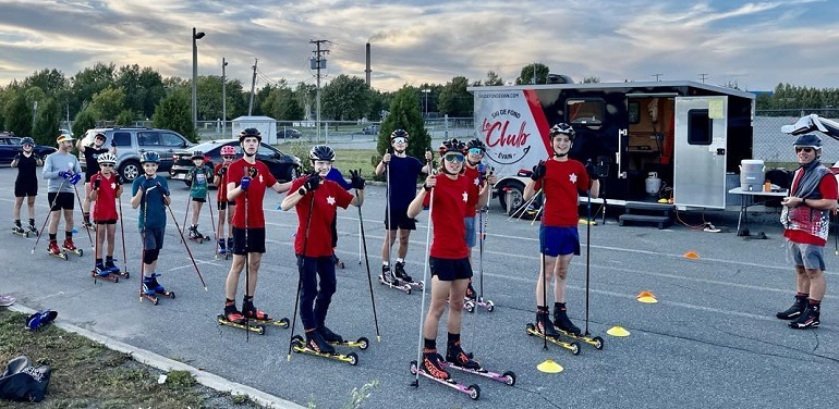 Groupe à l’entrainement, avec des skis à roulettes, sur un sol asphalté...